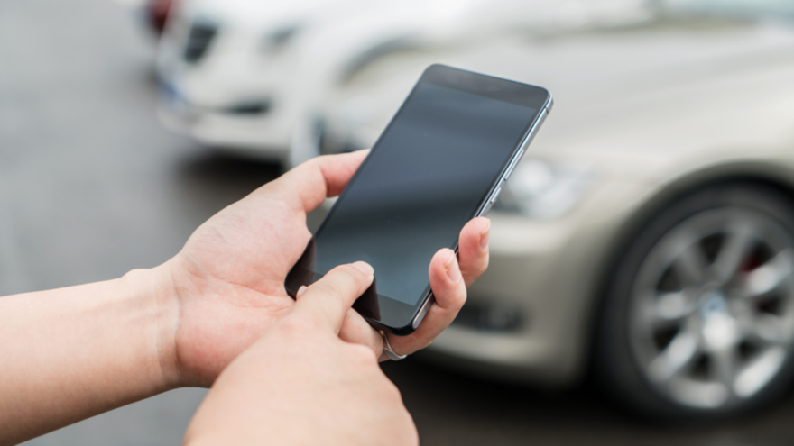 person on phone near cars